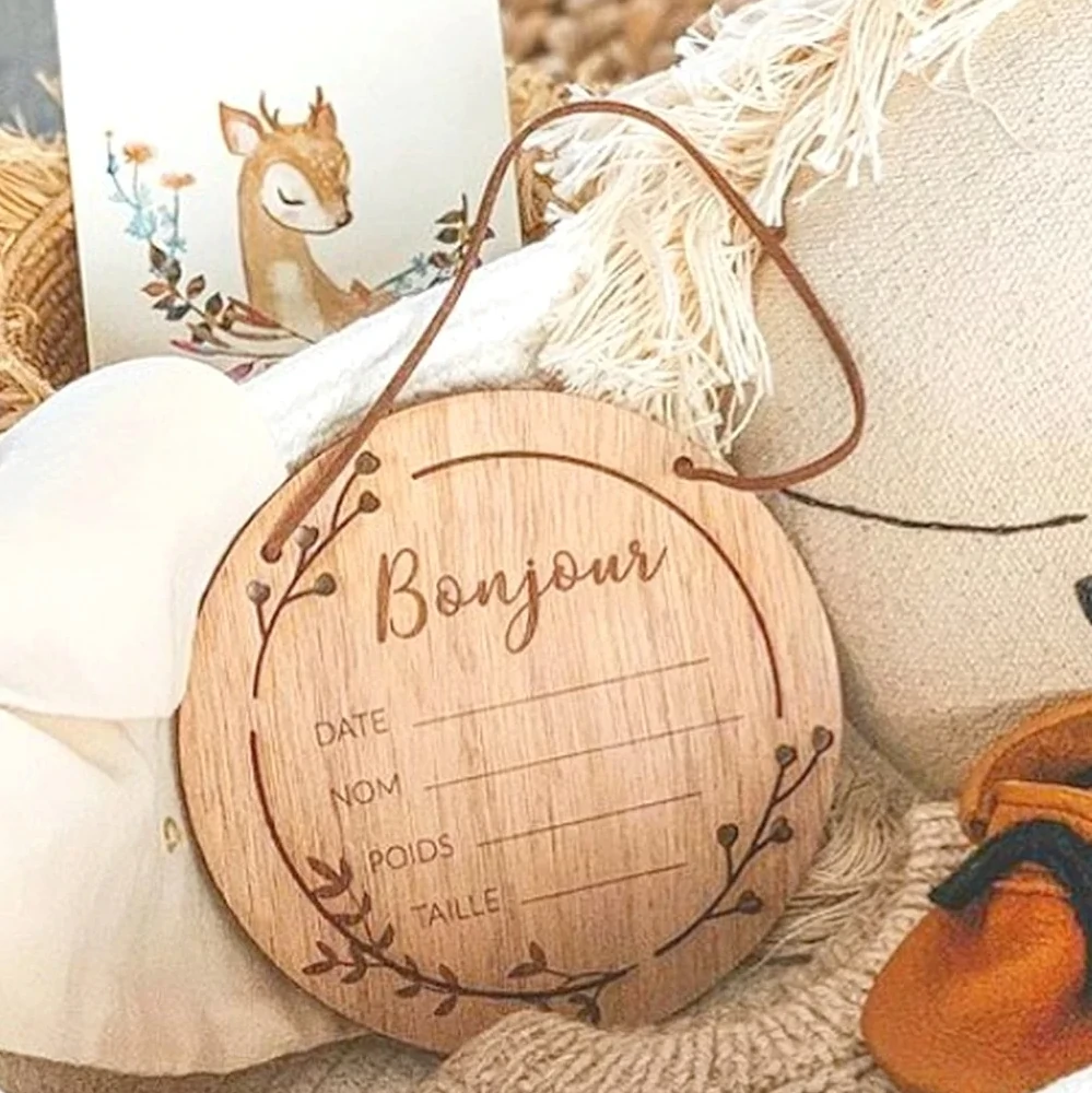 Médaillon de naissance en bois gravé posé sur un tissu naturel, souvenir personnalisé pour bébé et cadeau de naissance